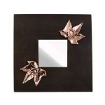 Mirror with two Ivy Leaves, made of shiny copper, placed on wooden mirror.