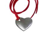 Solid Heart, Pendant, Silver 925°, hanging on a red suede cord.